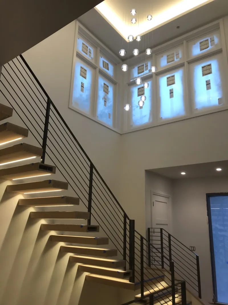 King Iron Works floating staircase with illuminated treads and slim metal railings