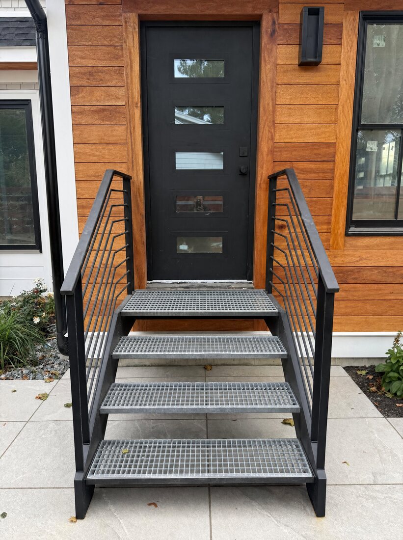 Floating exterior staircase with bar grating treads