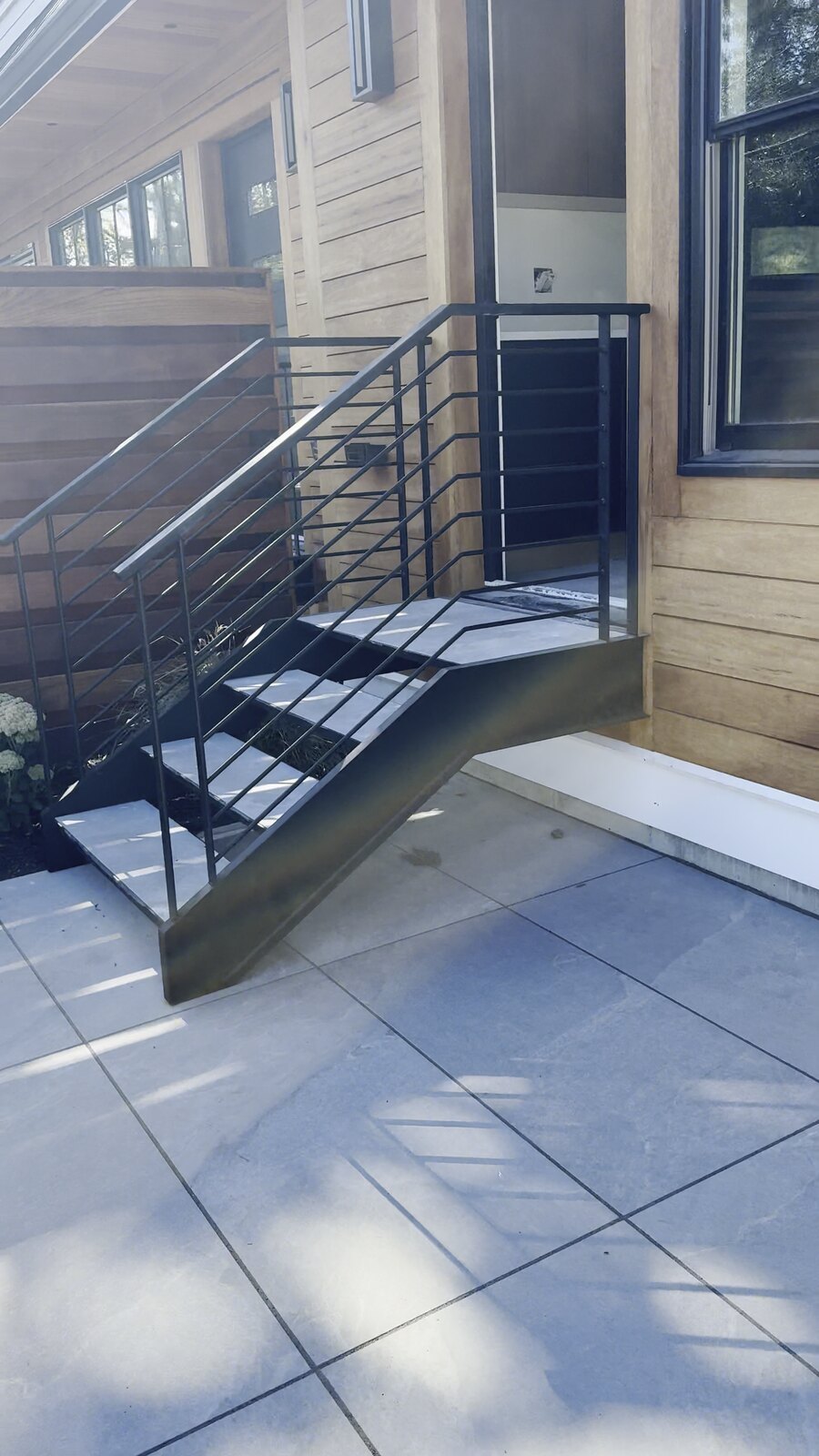 Sculpted steel stringer flaring out at the base of the staircase
